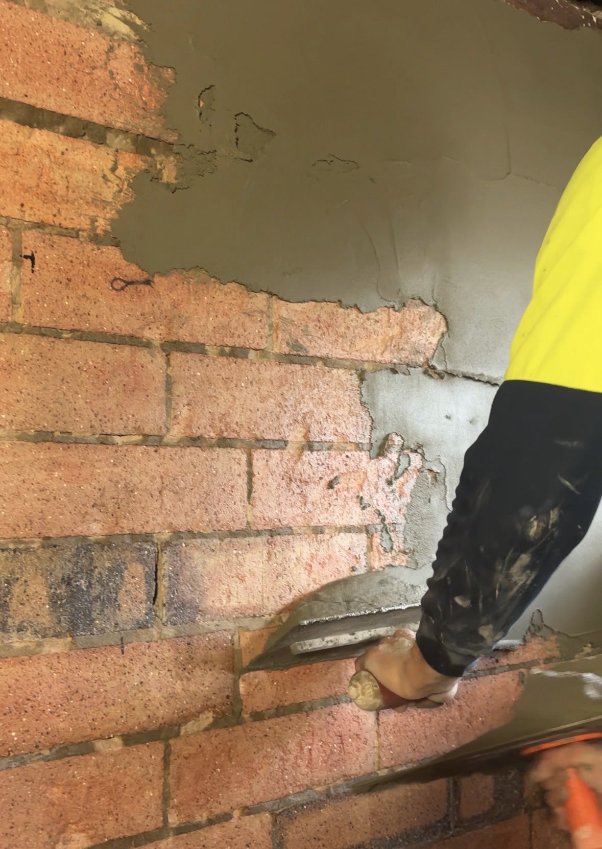 Plasterer applying a smooth internal plaster finish to a wall in a Perth home